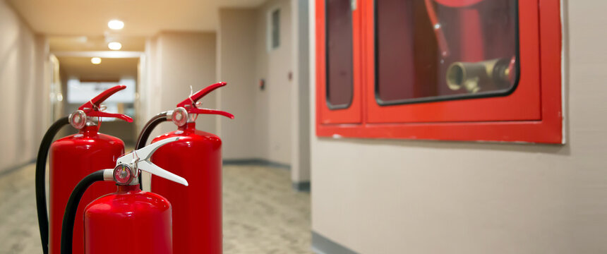 Red Fire Extinguishers Tank At The Exit Door In The Building Concepts Of Emergency Safety For Fire Prevention Rescue And Fire Services Concetps.