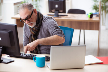 Old male employee working from house during pandemic