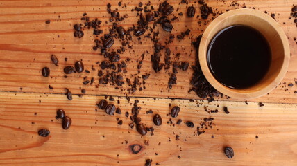 coffee beans and cup on the wooden background.