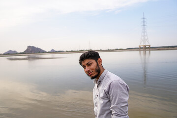 portrait of a young man on the beach staring at camera