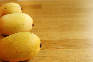A group of ripe mango on wooden table, Tropical fruit with copy space