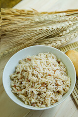  BROWN RICE in white bowl on wood table for health food content..