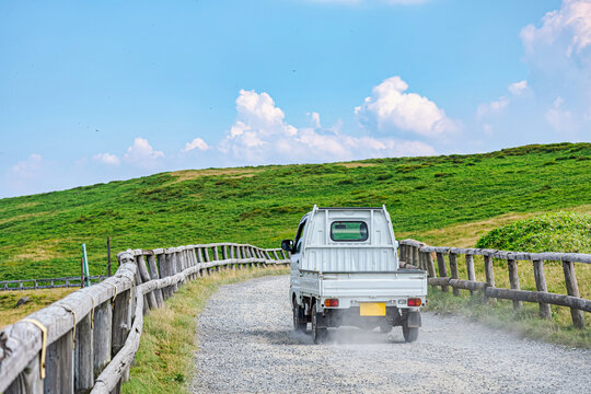 【運送イメージ】砂利道を走行中の軽トラック