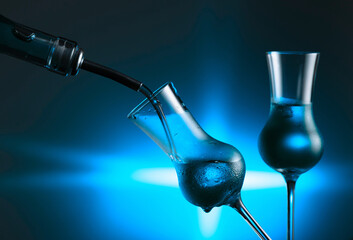 Strong alcoholic drinks in dammed glasses with ice on a blue background.