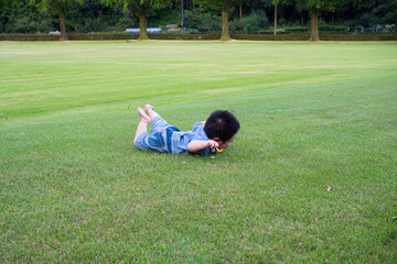 岐阜県の公園で寝ころんで遊ぶ日本人の赤ちゃん