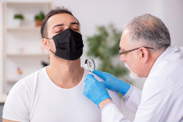 Young man visiting experienced doctor dermatologist