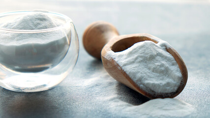 Glass bowl of baking soda. Spoonful of bicarbonate.