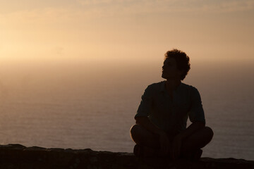 Male silhouette in the sunset. Oceanic view. Portugal, cabo da rocka. Man is young and curly. Copy space