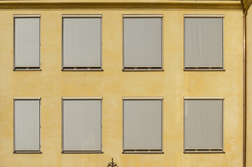 Sunny, Ochre Facade Detail with Windows and Blinds. Minimal Aesthetics.