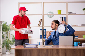 Young man delivering pizza to the office in time management conc