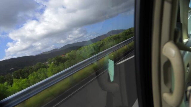 A short clip looking out of a moving vehicle onto a motorway and trees
