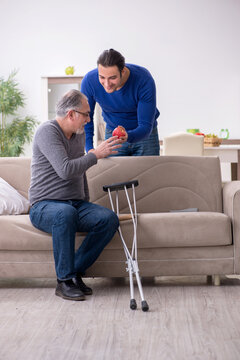 Young Man Looking After His Leg Injured Father