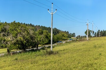Power poles next to a country road. Energy industry. Power lines in the Czech countryside.