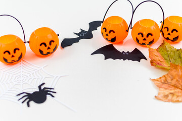 Halloween, pumpkins, bat silhouettes, spider web silhouette and paper spiders, on white background. Selective focus.