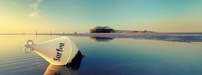 Boje und Pfahlhaus am Strand