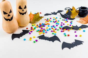 Halloween, pumpkins, bat silhouettes, spider web silhouette and paper spiders, on white background. Selective focus.