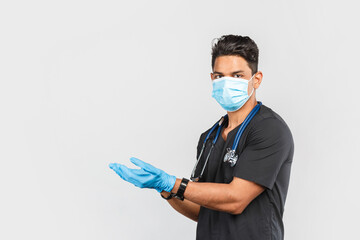  Indian / Asian doctor with stethoscope wearing blue medical face mask and gloves on gray background. protection against coronavirus