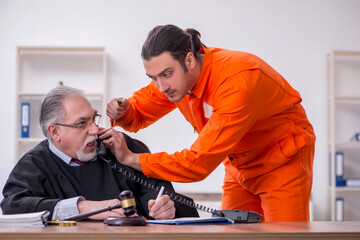 Old male judge meeting with young captive in courthouse