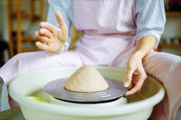 Potter hands sculpts a vase from clay on a Potter close up