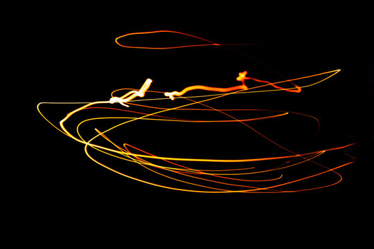 Creative Conceptual Fine Art Photography Motion Blur Sparkle Light Trail On Dark Background Copy Space For Text. Artistic design by lamp fire flame line at night slow shutter speed of camera exposure.
