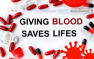 giving blood saves lifes. text on white paper on light background near medication