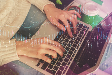 Double exposure of woman hands typing on computer and forex chart hologram drawing. Stock market invest concept.