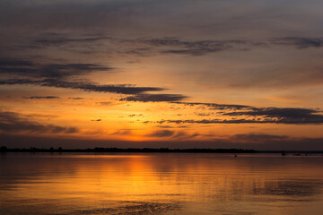 Sunrise at the river Drava in Croatia, warm red black and yellow dramatic colors of sunset landscape with huge sun, photo taken in peaceful early morning, burning fire sunrise sunset