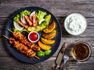 Fried souvlaki, potatoes with fresh vegetables
