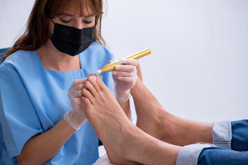Podiatrist treating feet during procedure