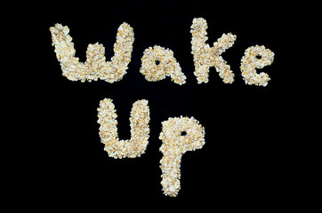 Wake Up words written with oatmeal. Healthy eating on a dark background