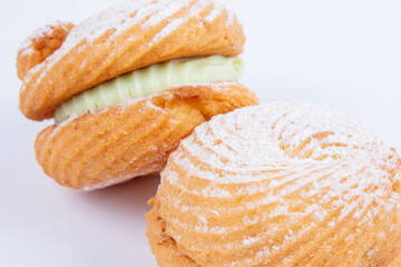 fresh pastry with filling, sprinkled with powdered sugar, isolated on a white background