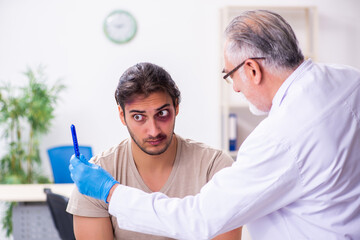 Young face injured man visiting experienced male doctor traumato