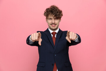 Naklejka premium happy elegant businessman in suit pointing fingers
