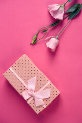 gift box and bouquet of flowers on pink background bow holidays top view
