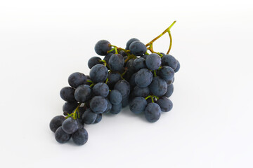 Black grapes, large fresh fruits with green leaves on a white background
