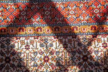 Colorful background. Light and shadow on a carpet