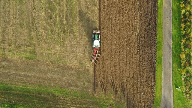 Tractor plowing a big field in the spring time, drone stock footage by DroneRune 3