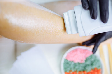 Sugaring: woman at cosmetics salon waxing legs