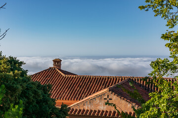 Fototapeta na wymiar View of a roof of a mountain house with the clouds at the same height.