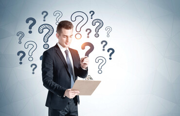 Businessman with clipboard, question marks