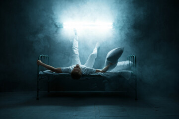 Psycho man lying in bed, insomnia horror