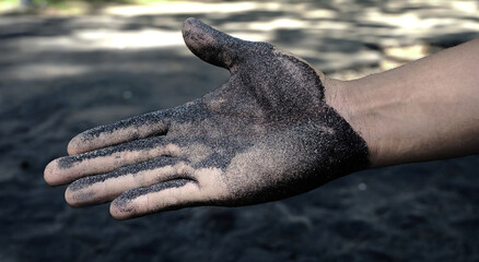 Selective focus, full hand of a man, spread out and cover with mineral sand or dirty sand