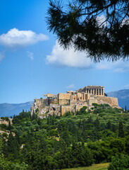 Fototapeta premium Great view of Acropolis hill from Pnyx hill on summer day with great clouds in blue sky, Athens, Greece. UNESCO world heritage. Propylaea, Parthenon.