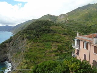 Fototapeta premium Cinque Terre, Italy - 08/31/2020: Beautiful landscape of a coastal fishing village, amazing view on many little colorful houses, traditional architecture of the little Italian town called Cinque Terre
