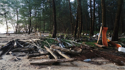 Selective focus, Pile of woods and wastes that floating over the sea and covered along the beach after storm