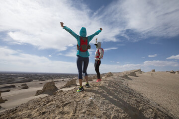 Two women trail runners cross country running  on sand desert dunes
