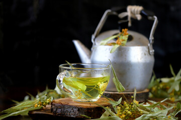 Soft focus. Fresh linden tea in a cup and in a teapot. Healthy herbal drink with linden tree. Linden flowers.