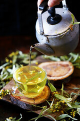 Soft focus. Fresh linden tea in a cup and in a teapot. Healthy herbal drink with linden tree. Linden flowers.