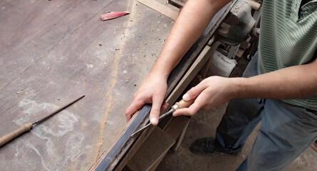 Male carpenter working on old wood in a retro vintage style.
