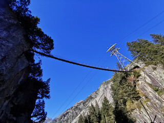 Hanging bridge over a valley. Path between rocks. Copy space
